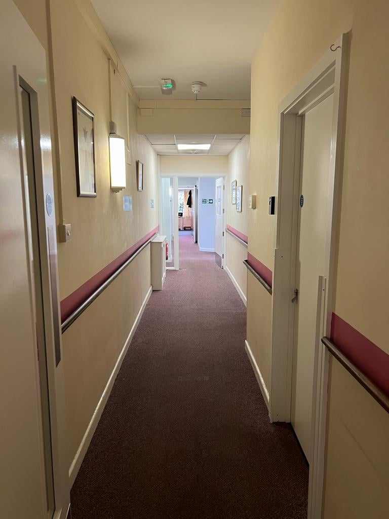 A poorly lit, dated Corton House corridor before refurbishment.