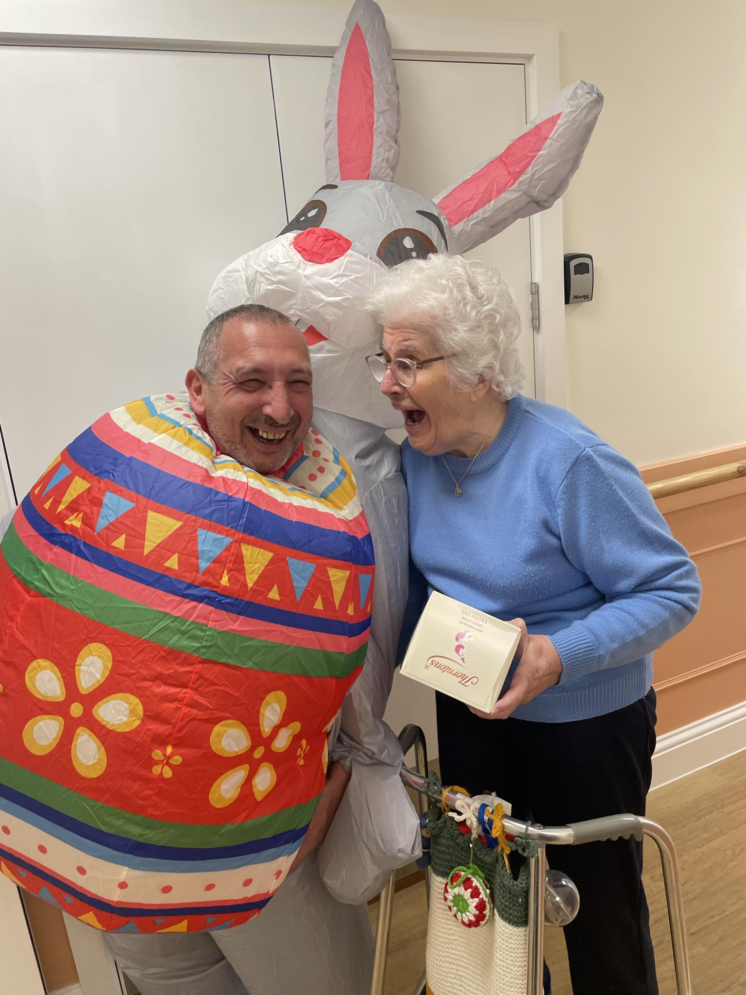 Resident and Manager Jason laughing, holding an Easter Egg