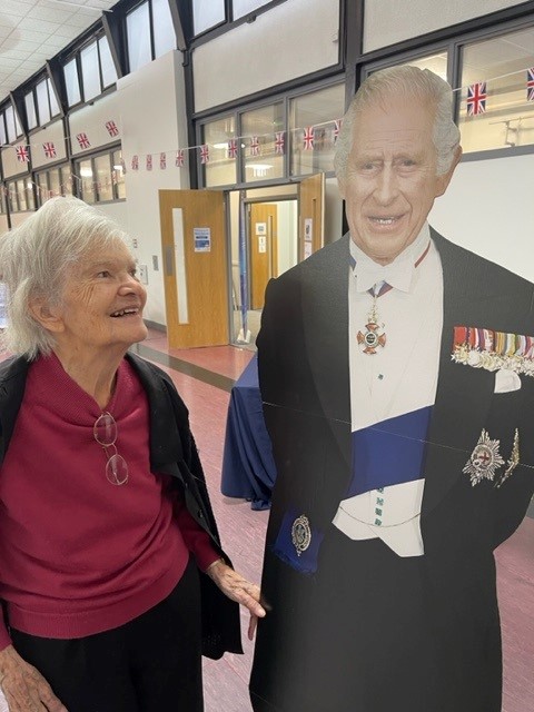 A resident smiles at a cardboard cut out of the King