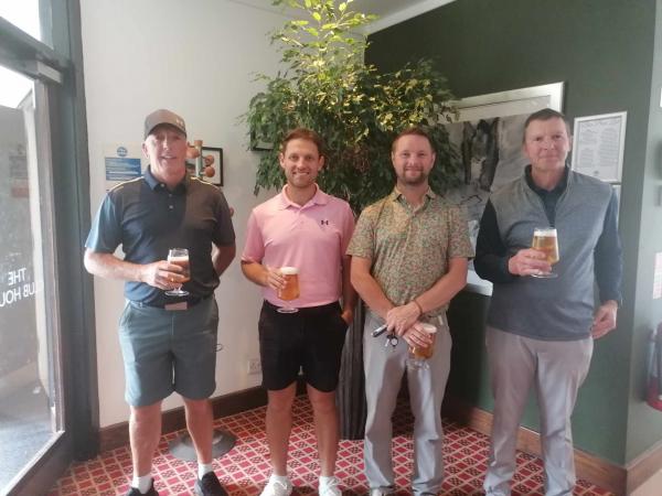 A smiling team of golfers holding their drinks