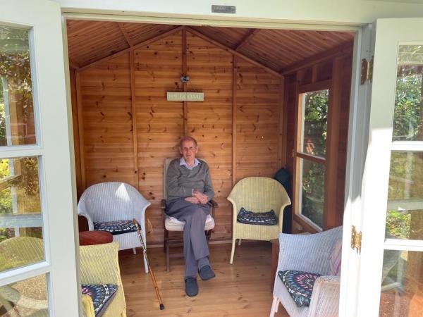 Resident David sits in the summer house in Corton House garden.