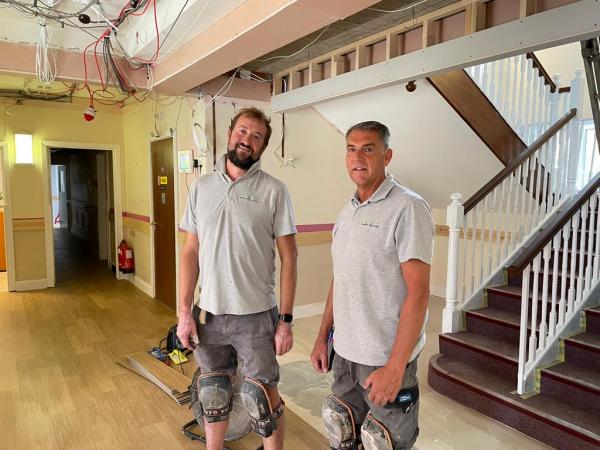 Tradespeople lay the new floor in Corton House foyer