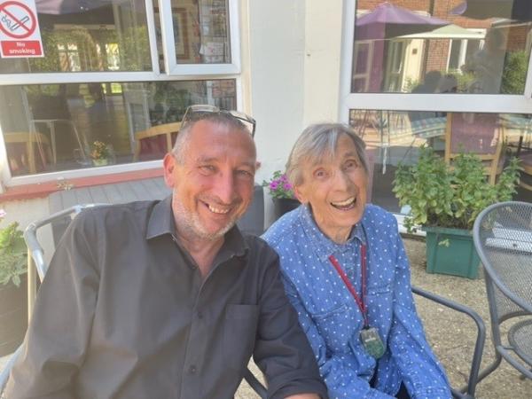 Registered Manager Jason has a chat with resident Alma on the patio