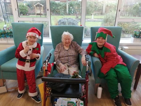 Corton House resident Joyce with her pen pals dressed in Christmas outfits
