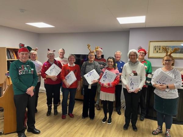 A choir dressed in Christmassy outfits sings for Norwich care home residents.