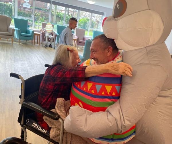 A resident and manager dressed as the Easter Bunny, hugging on Easter day