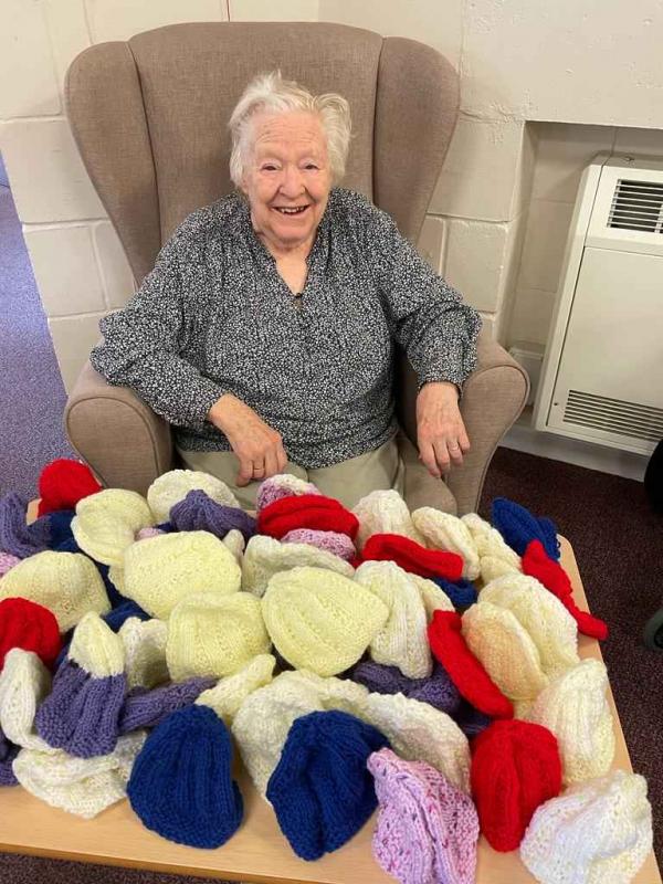 Norfolk care home resident with baby hats she has knitted for the local hospital