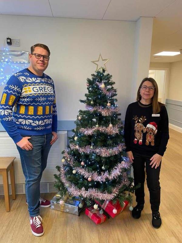 Staff at Norfolk care home Corton House wearing Christmas jumpers by the tree
