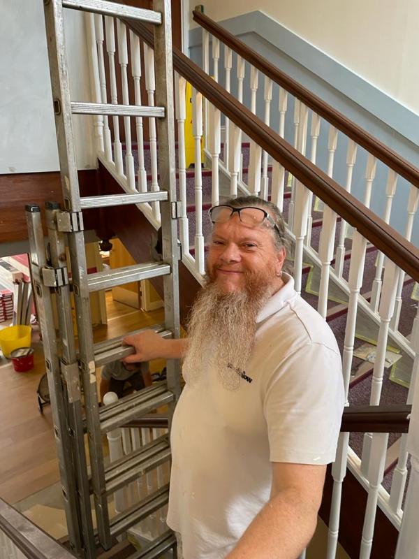 A smiling tradesperson on the main stairway in Corton House