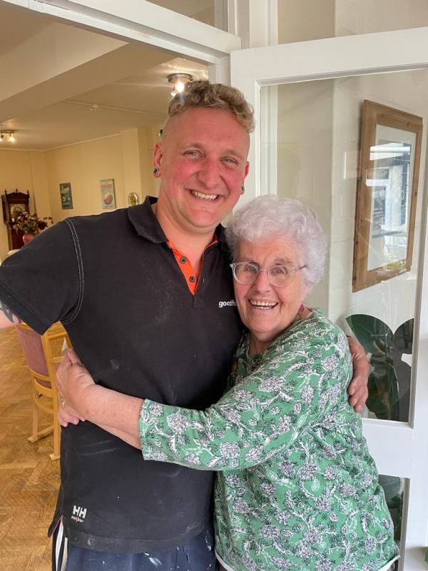 A smiling resident hugs a tradesperson in Corton House