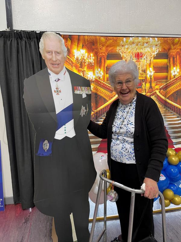 Corton House resident smiling with a cut out of the king