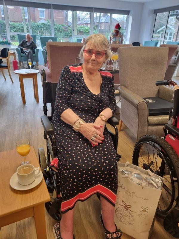 A smiling resident enjoys a festive drink in Corton House