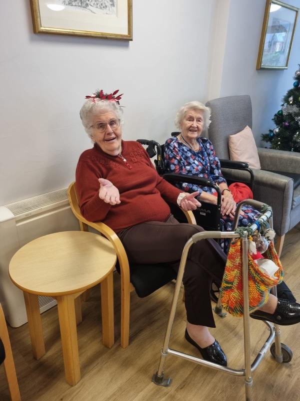 Two care home residents in Norwich on Christmas Day, smiling in the lounge