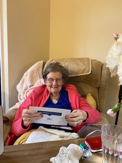 Care home resident receiving a Christmas card from Norwich School