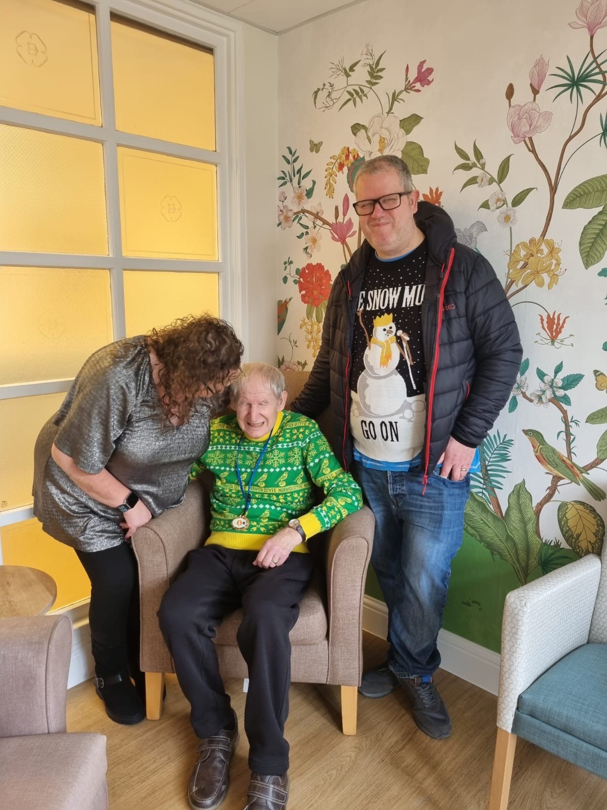 A seated resident spends time with visitors on Christmas day in Corton House