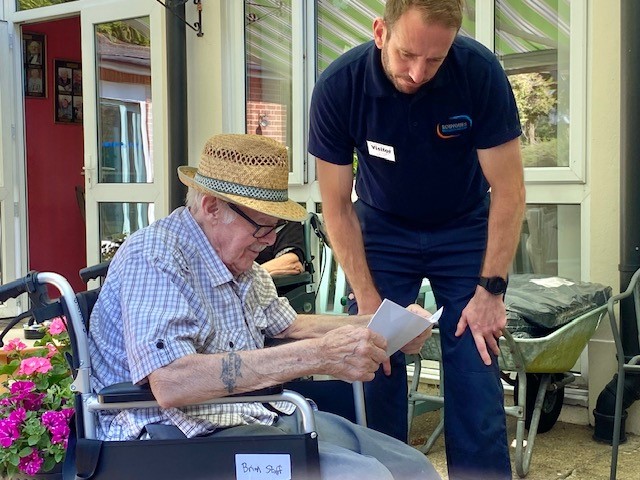 A volunteer and resident reading instructions before building a planter.