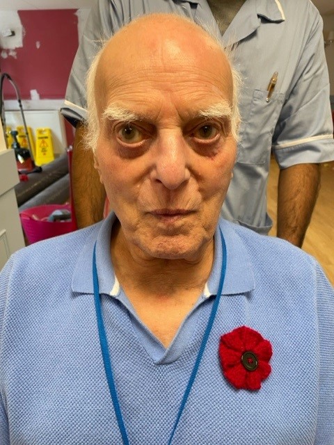A resident at norwich care home Corton House wears a knitted poppy