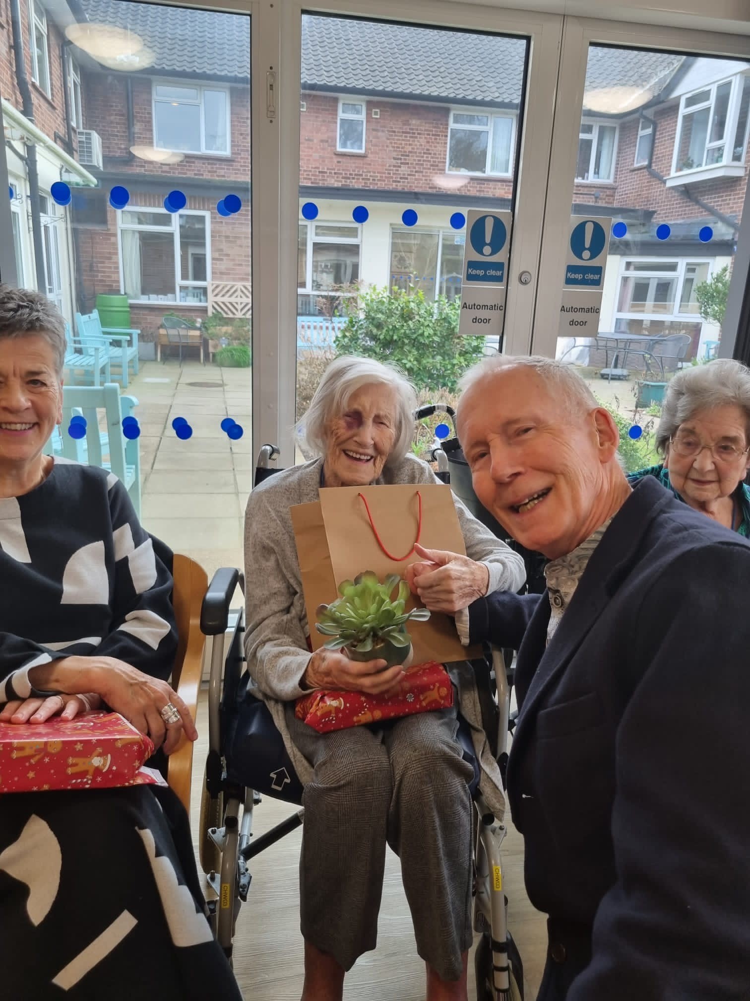 Residents and visitors hold presents and smile in Norwich care home Corton House